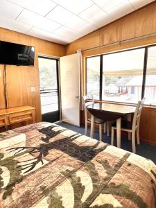 布里奇波特Willow Springs Resort的一间卧室配有一张床和一张桌子及椅子