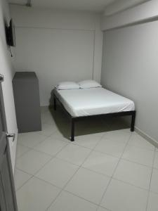 圣何塞Hotel Singapur的一间白色的小房间,里面设有一张床