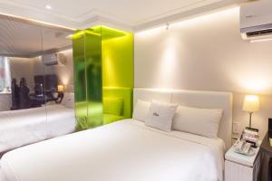 桃园市i hotel 桃园馆的一间卧室配有一张绿色的白色床。