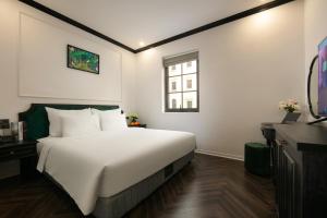 下龙湾Elegant Boutique Hotel Ha Long的卧室设有一张白色大床和一扇窗户。