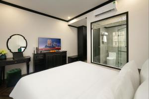 下龙湾Elegant Boutique Hotel Ha Long的卧室配有白色的床和镜子