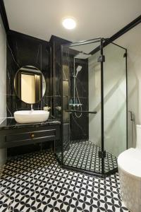 下龙湾Elegant Boutique Hotel Ha Long的黑色浴室设有水槽和镜子