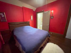 尼亚加拉瀑布THE RED STAR ROOM A的卧室设有红色的墙壁和蓝色的床。