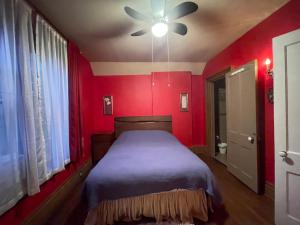 尼亚加拉瀑布THE RED STAR ROOM A的红色卧室设有一张床和一个吊扇