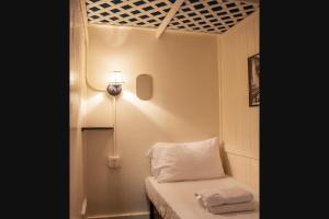 纽约The Nolita Express Hostel的小房间,设有一张床,墙上有灯