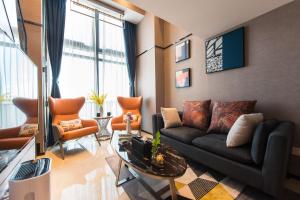 深圳尊享国际公寓(深圳福田会展中心店)的客厅配有黑色沙发和橙色椅子
