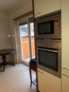 里斯本Apartamento Lisboa的厨房里炉灶上的一个微波炉