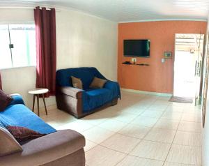 戈亚斯州上帕莱索Recanto da Chapada的带沙发和电视的客厅