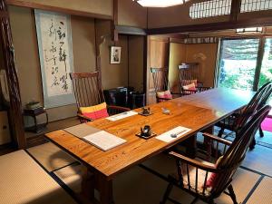 岛田Kappo Ryokan Uoichi的一间带木桌和椅子的用餐室