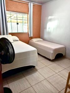 戈亚斯州上帕莱索Recanto da Chapada的带窗户的客房内的两张床