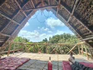 黎明之村Chords of Nature Hostels & Hut Stays Pondicherry的躺在茅屋茅草屋顶上的人