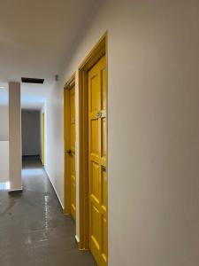 士姑来Jb Sojourn的一条空的走廊,有黄色的门和地板