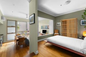 悉尼'Laube 105' Modern Inner-city Sanctuary with Balcony的一间卧室配有一张床、一张桌子和一张桌子