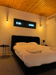 利马索尔Pirella House的一间卧室设有一张带木制天花板的大床