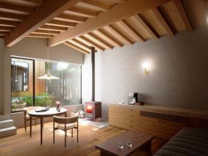 箱根Hakone Retreat villa 1f的客厅配有桌子和壁炉