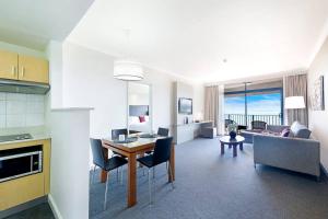 达尔文Sky-high Waterfront Living across Two Apartments的厨房以及带桌椅的起居室。