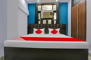 德里OYO Flagship Hotel Elite Inn的一间卧室配有一张带红色枕头的大床