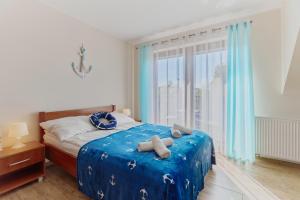 格里兹鲍Villa Konwalia的一间卧室配有一张带蓝色床单的床和一扇窗户。