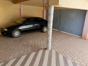 瓦加杜古Résidence lynda prestige Ouaga 2000的把车停在一个车库里,旁边是杆子