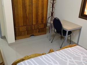 瓦加杜古Résidence lynda prestige Ouaga 2000的一间卧室配有书桌、桌子和椅子