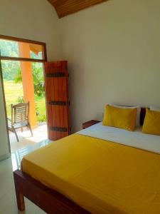代尼耶耶Sinharaja Serenity的一间卧室设有一张大黄床和滑动玻璃门