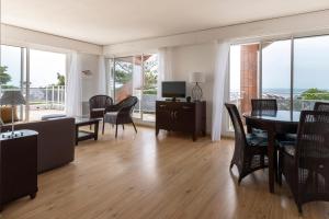 基伯龙Louison Appart & Suite的客厅配有桌椅和电视。