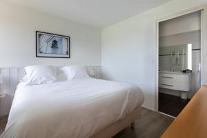 基伯龙Louison Appart & Suite的卧室配有一张白色大床和镜子