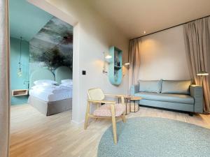 基尔基尔考夫曼罗曼蒂克酒店的一间卧室配有一张床、一张沙发和一张桌子