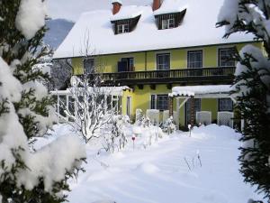 滨湖费尔德Cozy Apartment in Feld am See near Ski Slopes的一座黄色的房子,地面上积雪