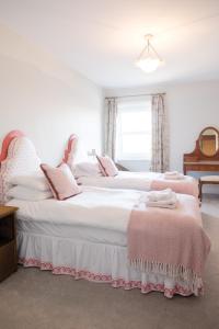 朴次茅斯Southsea, Portsmouth - Two Bedroom Apartment - Newly Refurbished Throughout - Treetop Sea Views的白色客房内的两张床和粉红色枕头