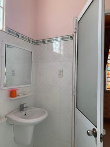 Hố NaiKHÁCH SẠN HOÀNG TRÍ 89 (HOANG TRI 89 HOTEL)的白色的浴室设有水槽和淋浴。