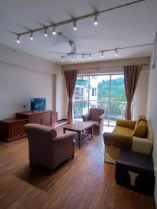 伯恩仓The Little Star Hotel & Studio at Star Regency Residence的客厅配有家具和大窗户