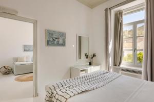 伊兹拉海德拉酒店的白色的卧室设有床和窗户
