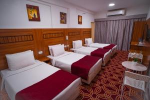 迪拜AL KARNAK HOTEL - BRANCH的酒店客房设有三张床和一张桌子