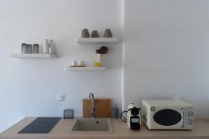 图罗斯Megusta Mykonos的厨房柜台配有微波炉和水槽