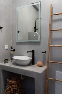 图罗斯Megusta Mykonos的浴室设有水槽和镜子,位于柜台上
