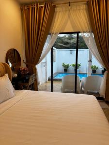 芙蓉Angsamas Villa Seremban Kids Private Pool & Jacuzzi的一间卧室配有一张床,享有游泳池的景色