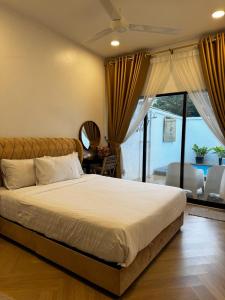 芙蓉Angsamas Villa Seremban Kids Private Pool & Jacuzzi的一间带大床的卧室和一个阳台