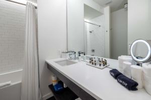纳什维尔121 Hotel by AvantStay Chic Modern Hotel In Nashville的白色的浴室设有水槽和镜子