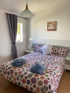 卡兰博希Apartamento Bellavista的一间卧室配有一张带五颜六色棉被的床