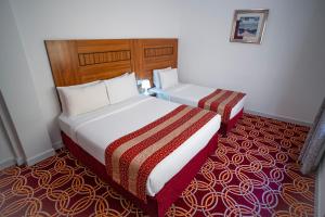 迪拜AL KARNAK HOTEL - BRANCH的酒店客房,设有两张床,铺有红地毯。