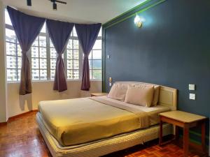 伯恩仓The Little Star Hotel & Studio at Star Regency Residence的一间卧室设有一张大床,拥有蓝色的墙壁和窗户。