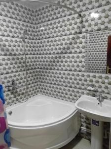 乌尔根奇NIYAT HOTEL的浴室配有白色浴缸和水槽