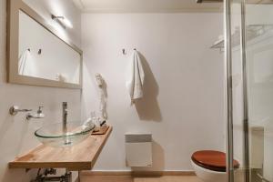伊兹拉海德拉酒店的一间带玻璃碗水槽和卫生间的浴室