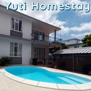 卡特勒博尔纳Yuti Homestay的一座房子前面设有游泳池