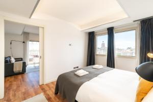 巴塞罗那Unique Rentals - Placa Catalunya Central Apartments的卧室设有白色大床和窗户。