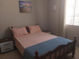 卡特勒博尔纳Yuti Homestay的一间小卧室,配有一张带粉红色和蓝色床单的床