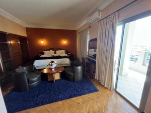 梅克内斯马耳他酒店的酒店客房带一张床、一张桌子和椅子