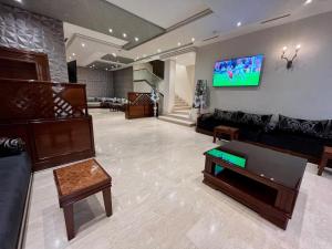 梅克内斯马耳他酒店的客厅配有沙发和墙上的电视