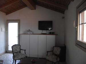 库尼亚纳Casa Marcella Cugnana-Portisco的客厅配有两把椅子和电视